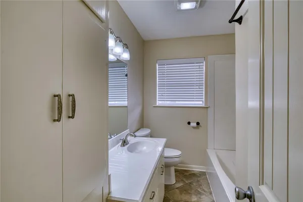 a bathroom with a sink a toilet a mirror and shower