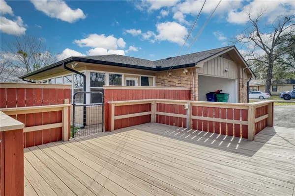 a view of a house with a wooden deck and a yard