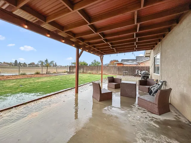 a view of a porch with furniture and a yard