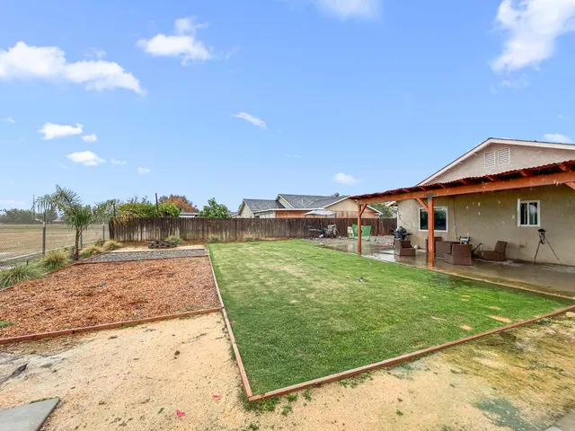 a view of a patio with a table and chairs under an umbrella