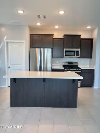 a kitchen with stainless steel appliances a refrigerator and a stove top oven