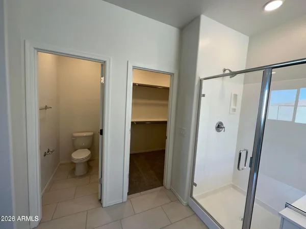 a bathroom with a granite countertop toilet and a shower