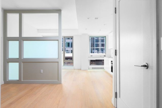 a view of a livingroom with wooden floor and a large window