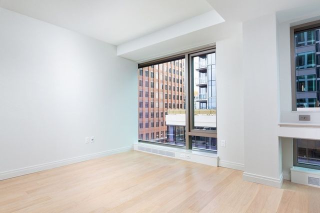 an empty room with windows and fireplace