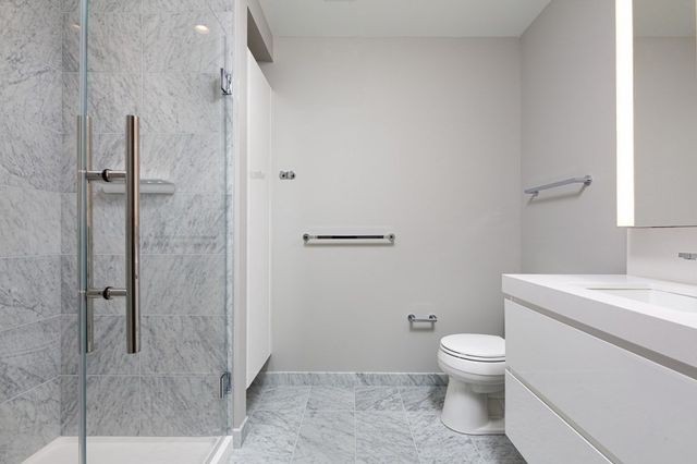 a white toilet sitting next to a bathroom sink