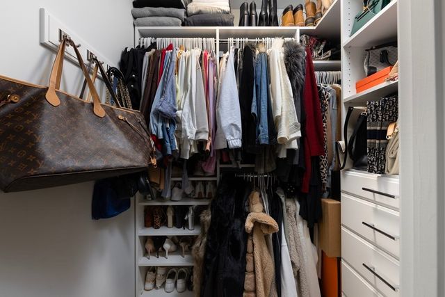 a view of walk in closet with clothes and shoes