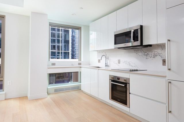 a kitchen with granite countertop white cabinets stainless steel appliances and sink