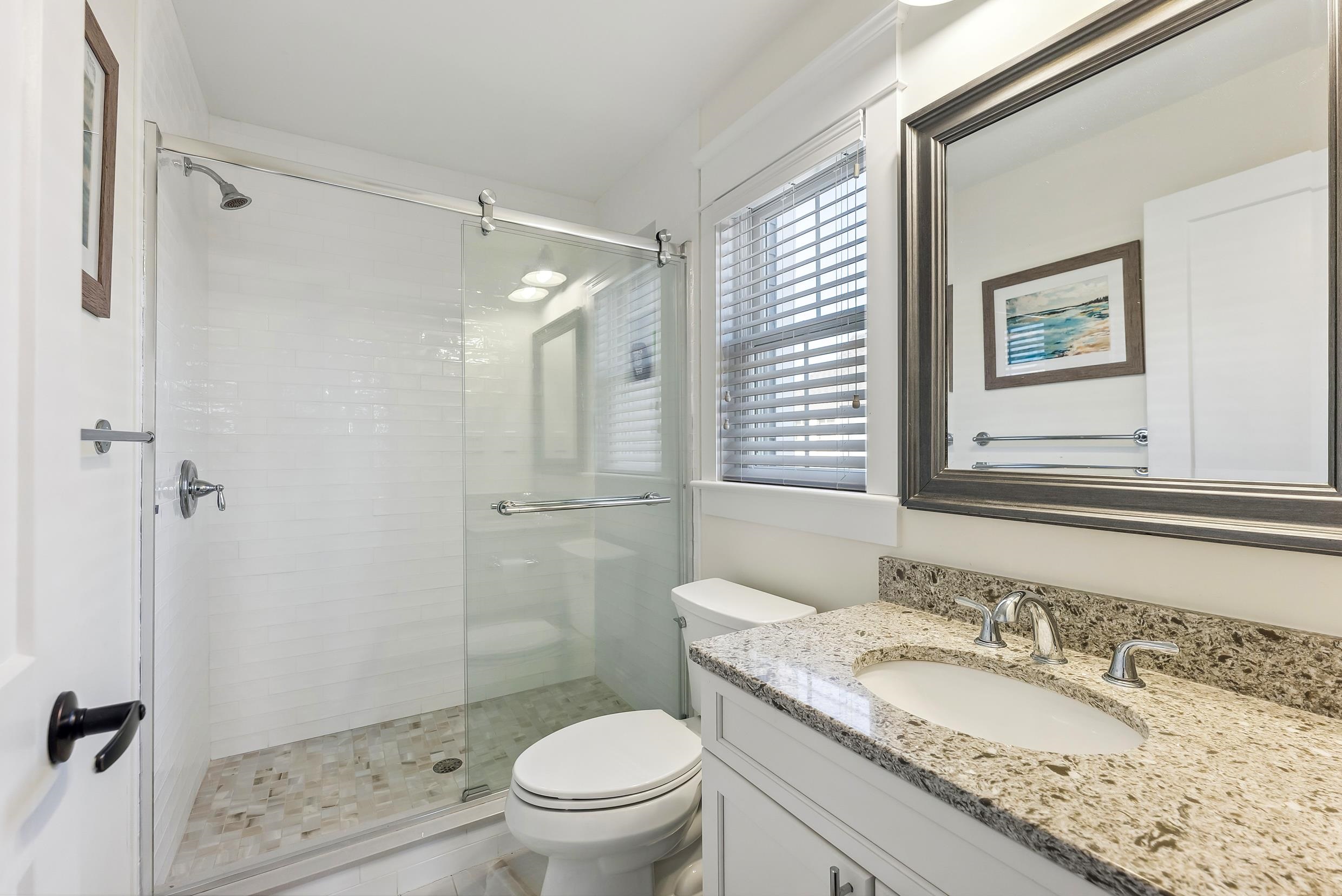 149 10th Street Avalon, NJ 08202 - Photo 36 of 49 a bathroom with a granite countertop sink toilet a mirror and shower