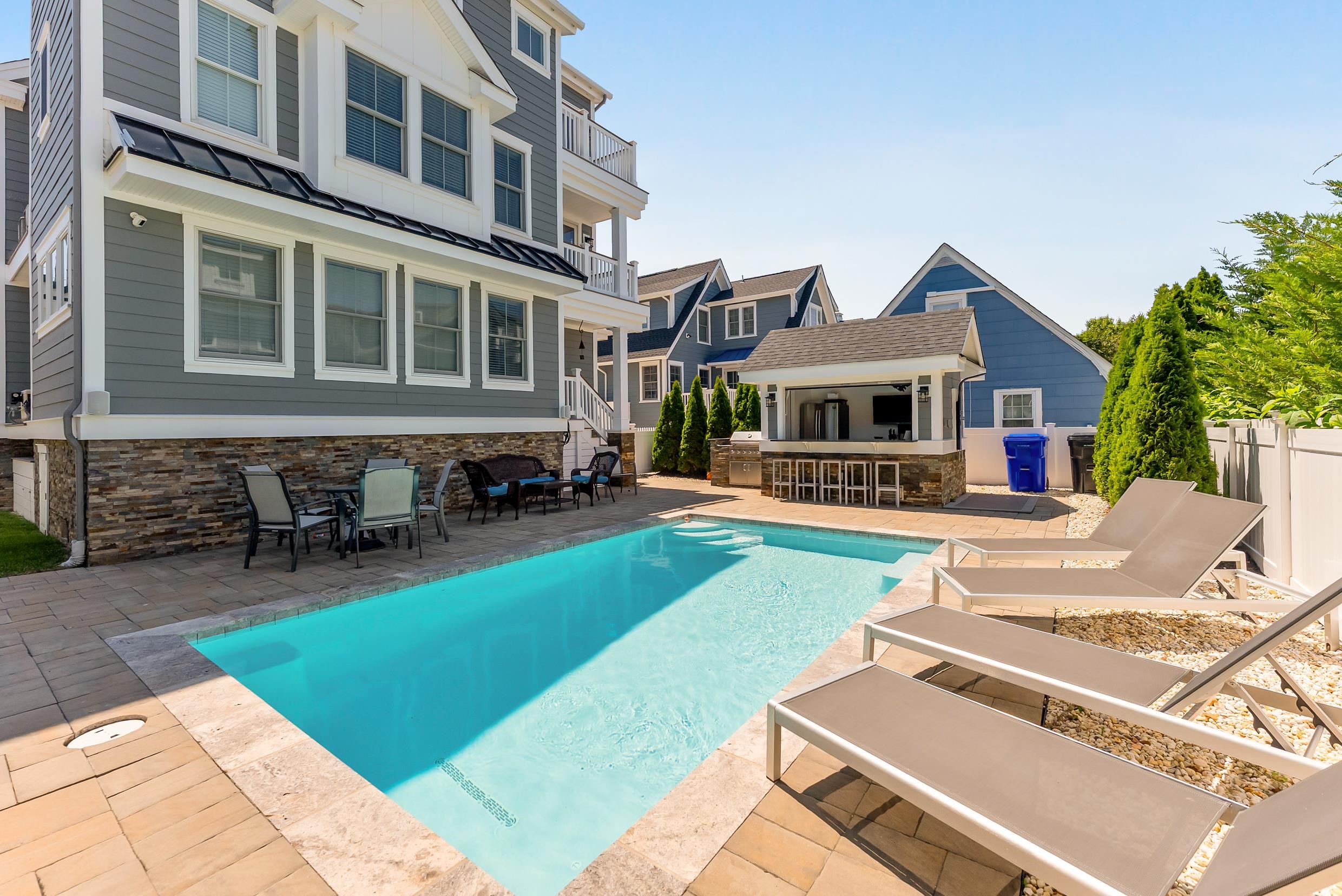 149 10th Street Avalon, NJ 08202 - Photo 4 of 49 a front view of a house with swimming pool and sitting area