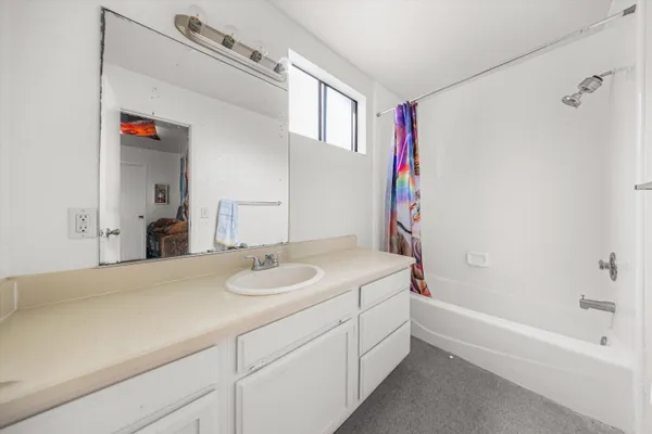 a en suite bathroom with a sink a large mirror and a bathtub