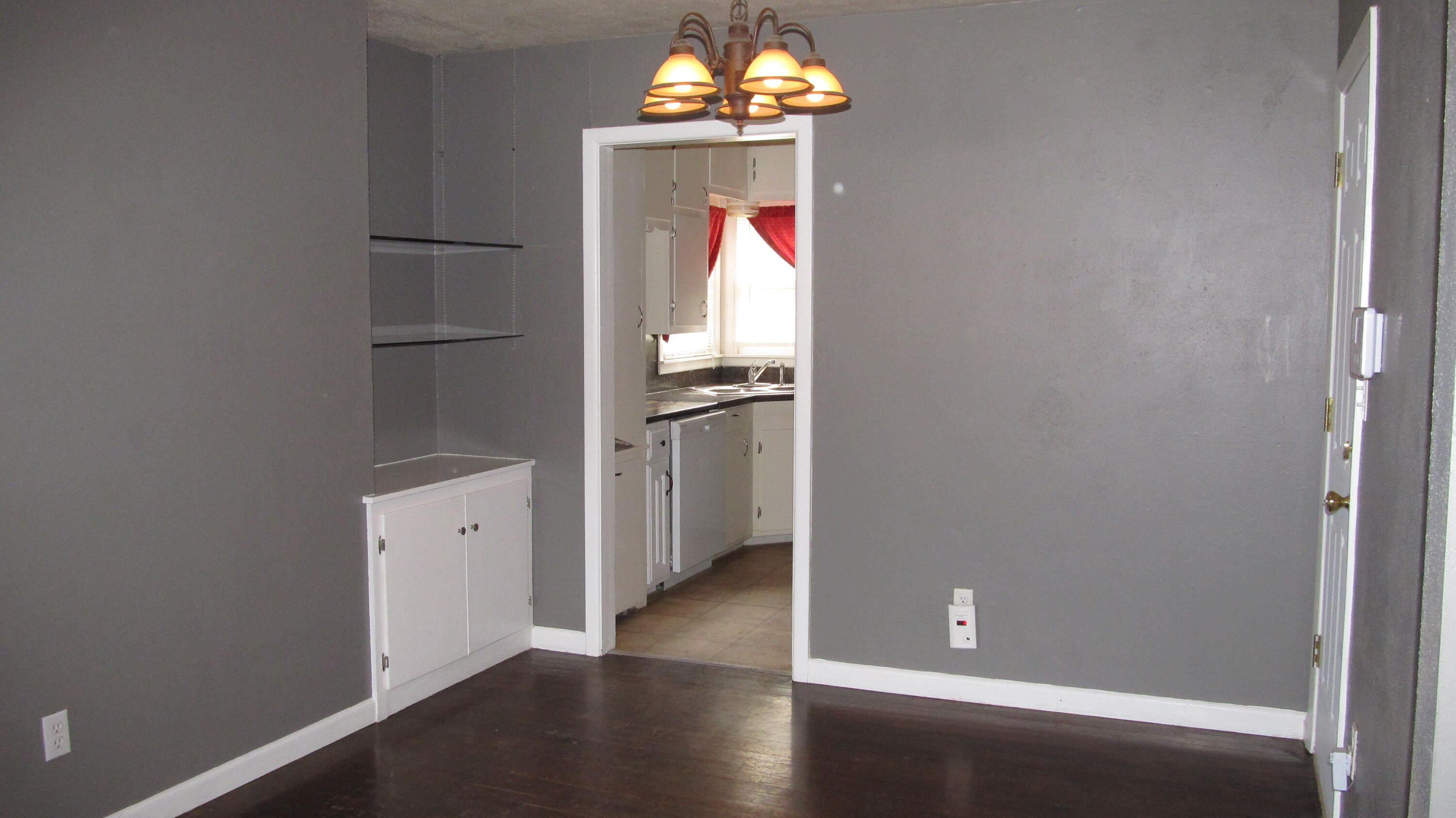 2013 48th Street Lubbock, TX 79412 - Photo 4 of 7 an empty room with wooden floor cabinet and a kitchen