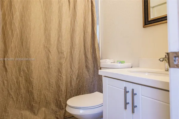 a bathroom with a sink a toilet and shower curtain
