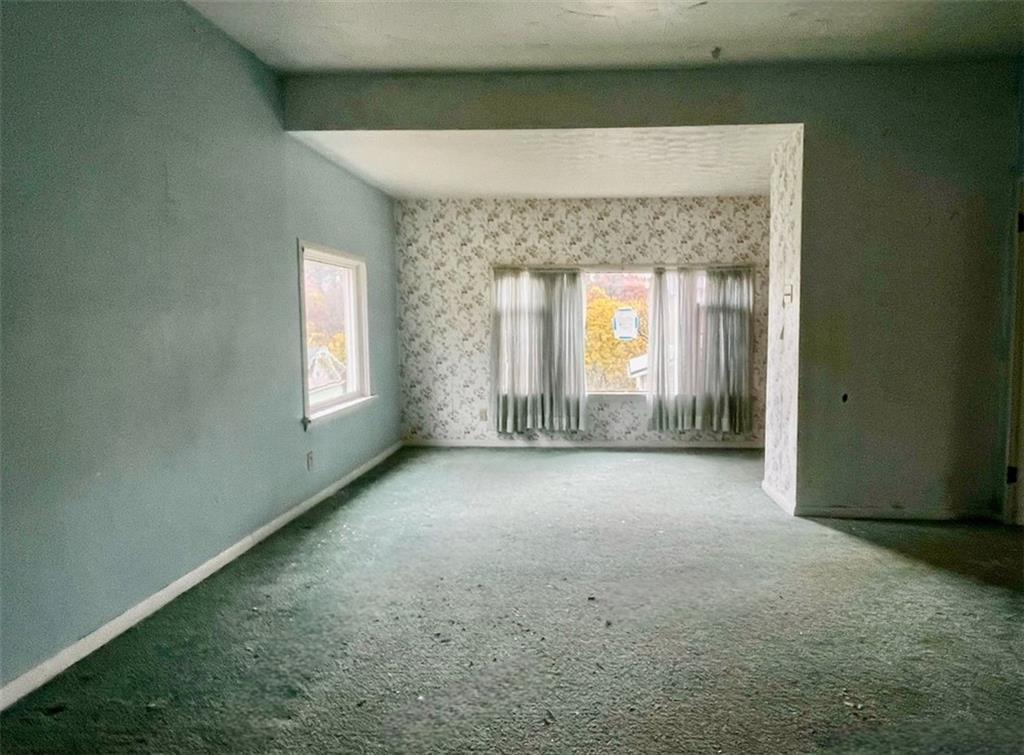 2409 25th Street Beaver Falls, PA 15010 - Photo 6 of 20 an empty room with a fireplace and windows