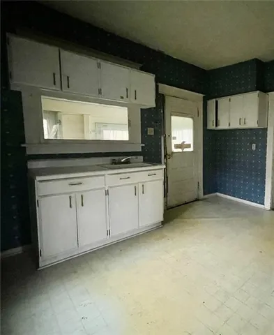 a kitchen with granite countertop white cabinets and white appliances