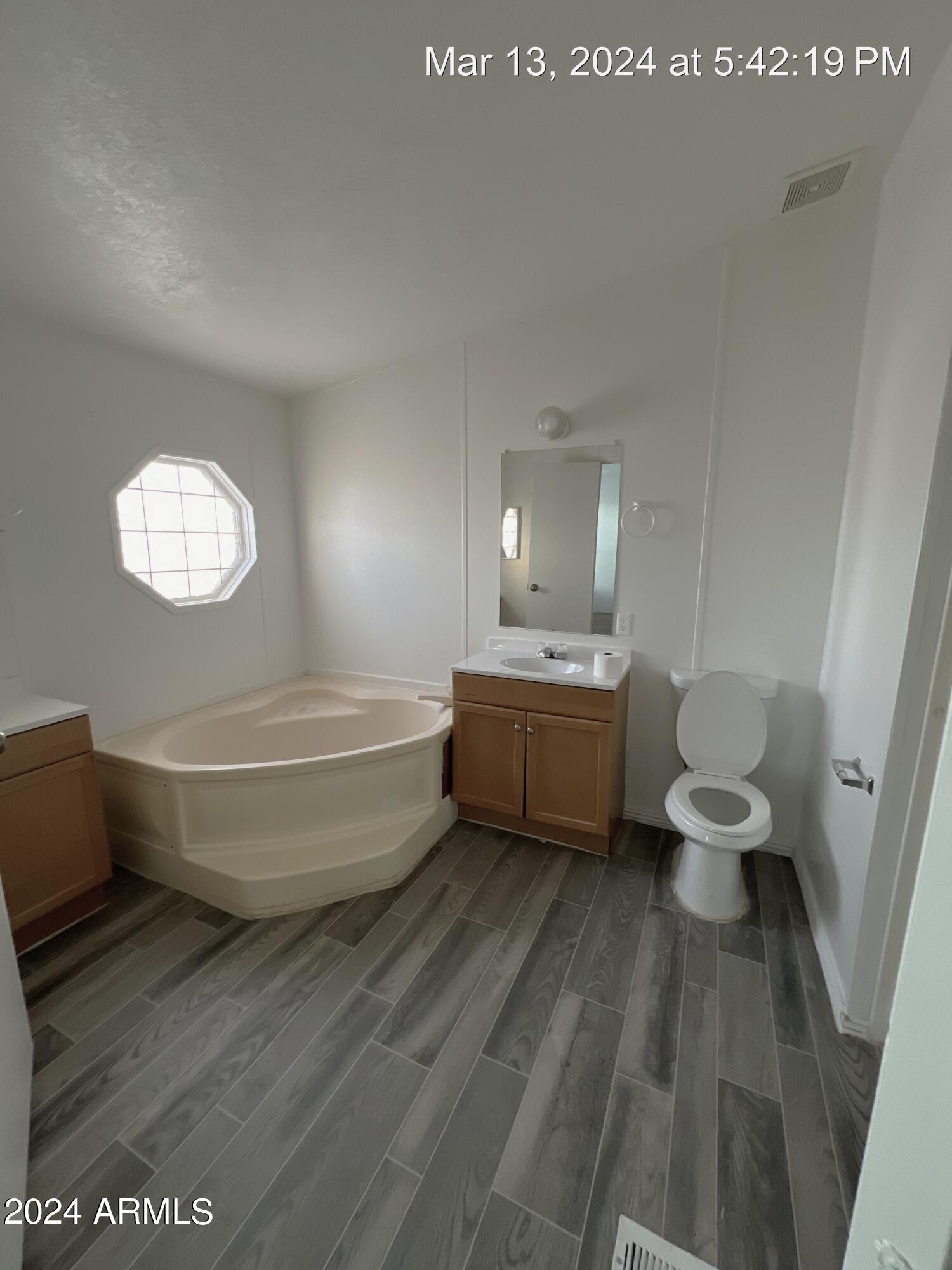 22548 West Skinner Road Wittmann, AZ 85361 - Photo 15 of 25 a bathroom with a sink a toilet a mirror and bathtub