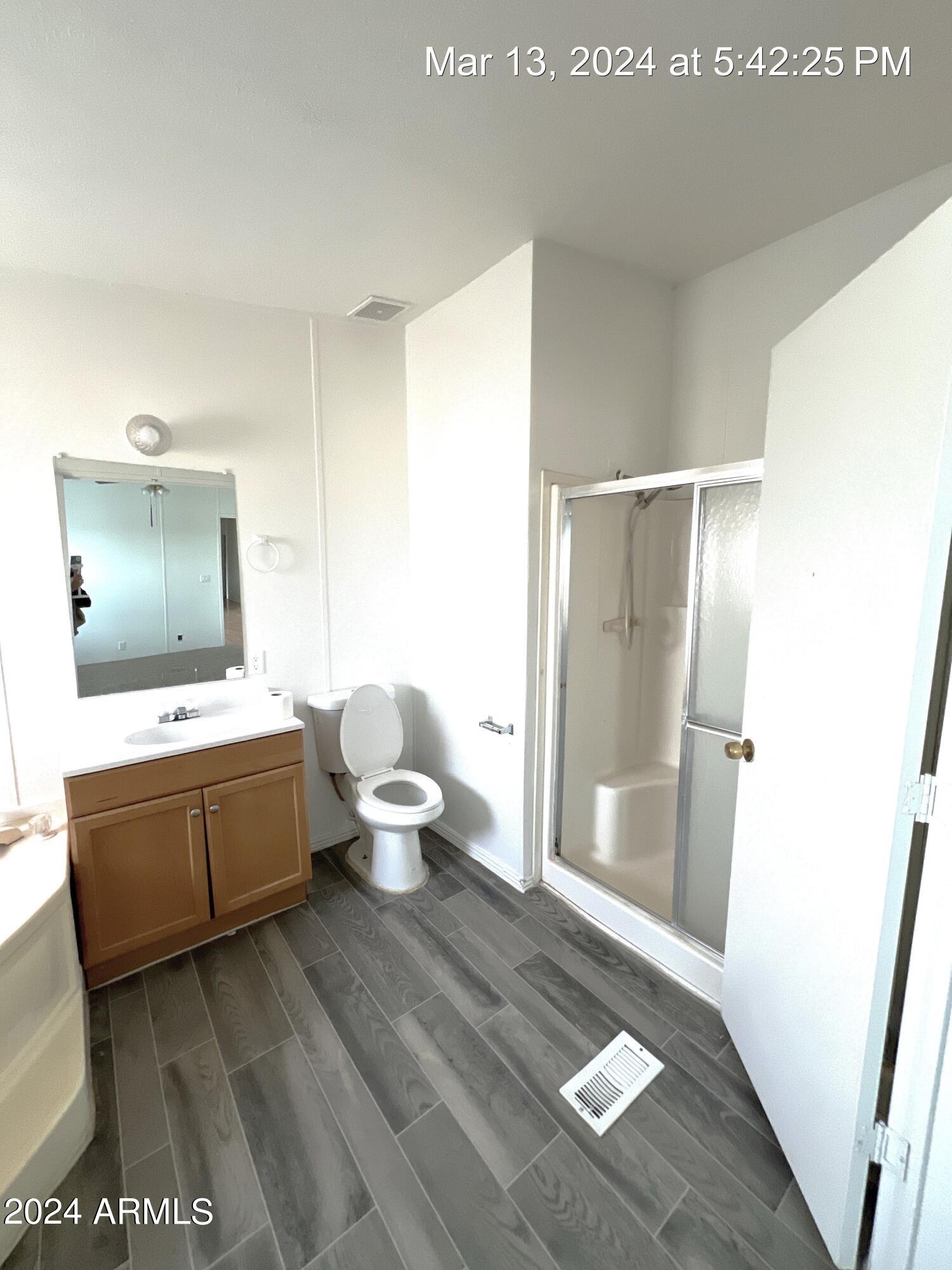 22548 West Skinner Road Wittmann, AZ 85361 - Photo 17 of 25 a spacious bathroom with a granite countertop sink a toilet and shower