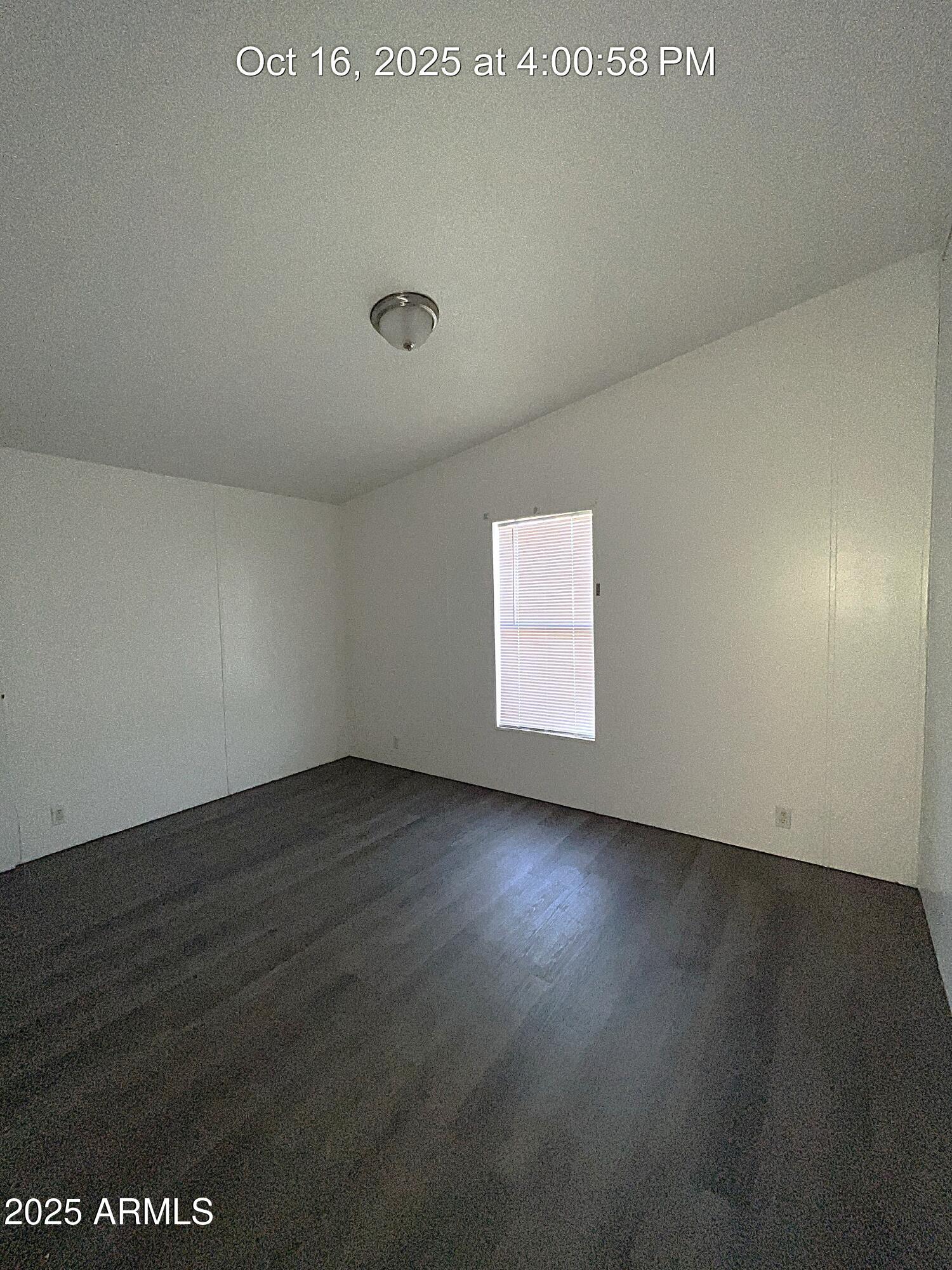 22548 West Skinner Road Wittmann, AZ 85361 - Photo 19 of 25 an empty room with wooden floor and windows in it