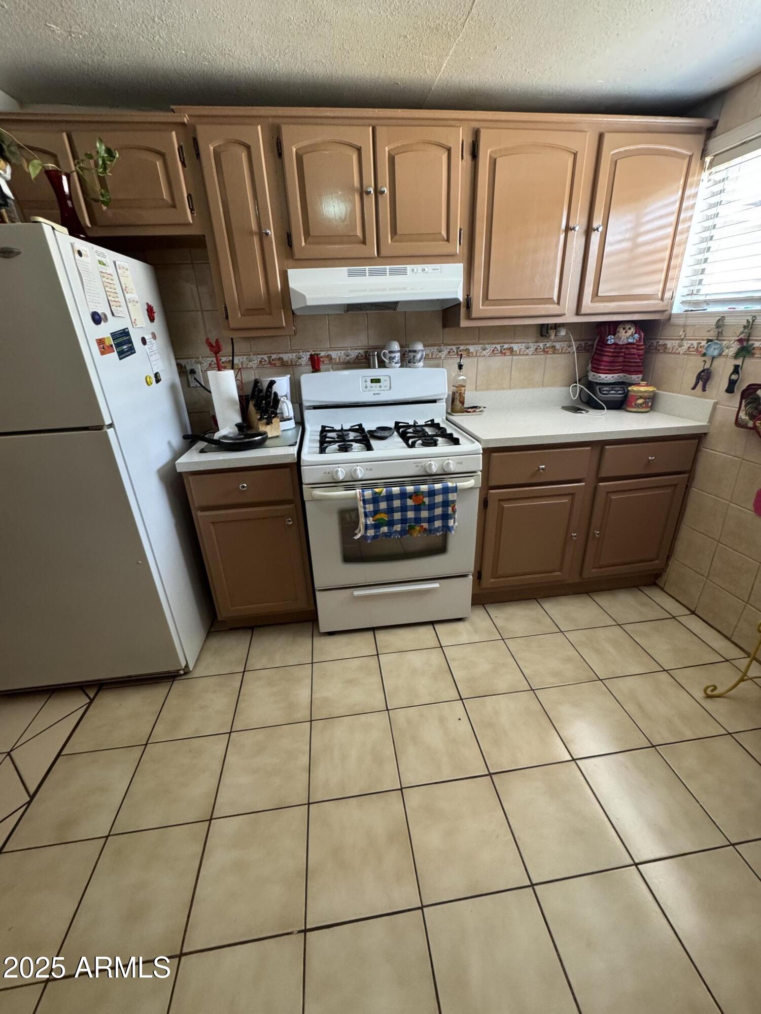 6515 North 59th Drive Glendale, AZ 85301 - Photo 34 of 47 a kitchen with stainless steel appliances a sink a stove a microwave and cabinets