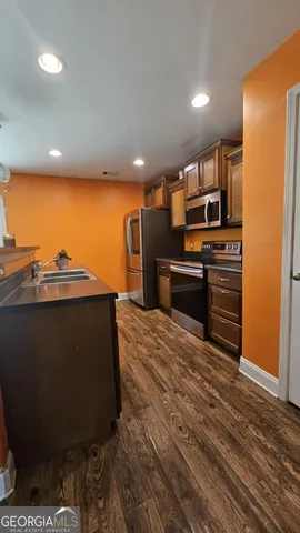 a kitchen with stainless steel appliances granite countertop a stove a sink and a refrigerator