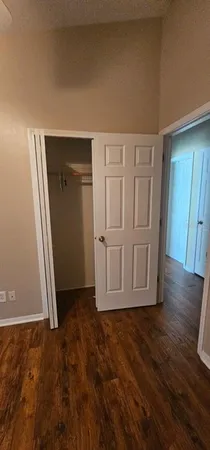 an empty room with wooden floor and cabinet