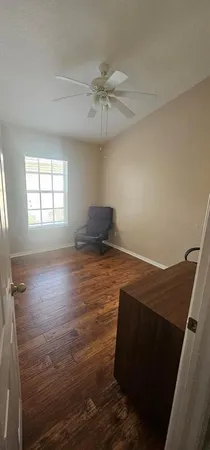 a view of empty room with window and ceiling fan