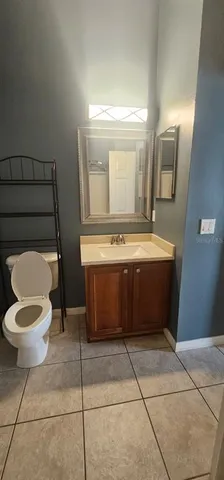 a bathroom with a toilet mirror and vanity