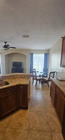 a large kitchen with stainless steel appliances granite countertop a barbecue grill and couches