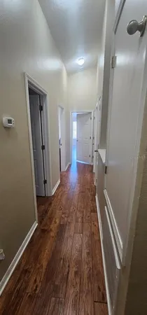 a view of a hallway with wooden floor