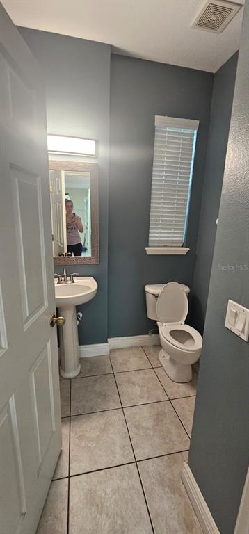 8504 Shallow Creek Court New Port Richey, FL 34653 - Photo 10 of 28 a bathroom with a toilet a sink and mirror