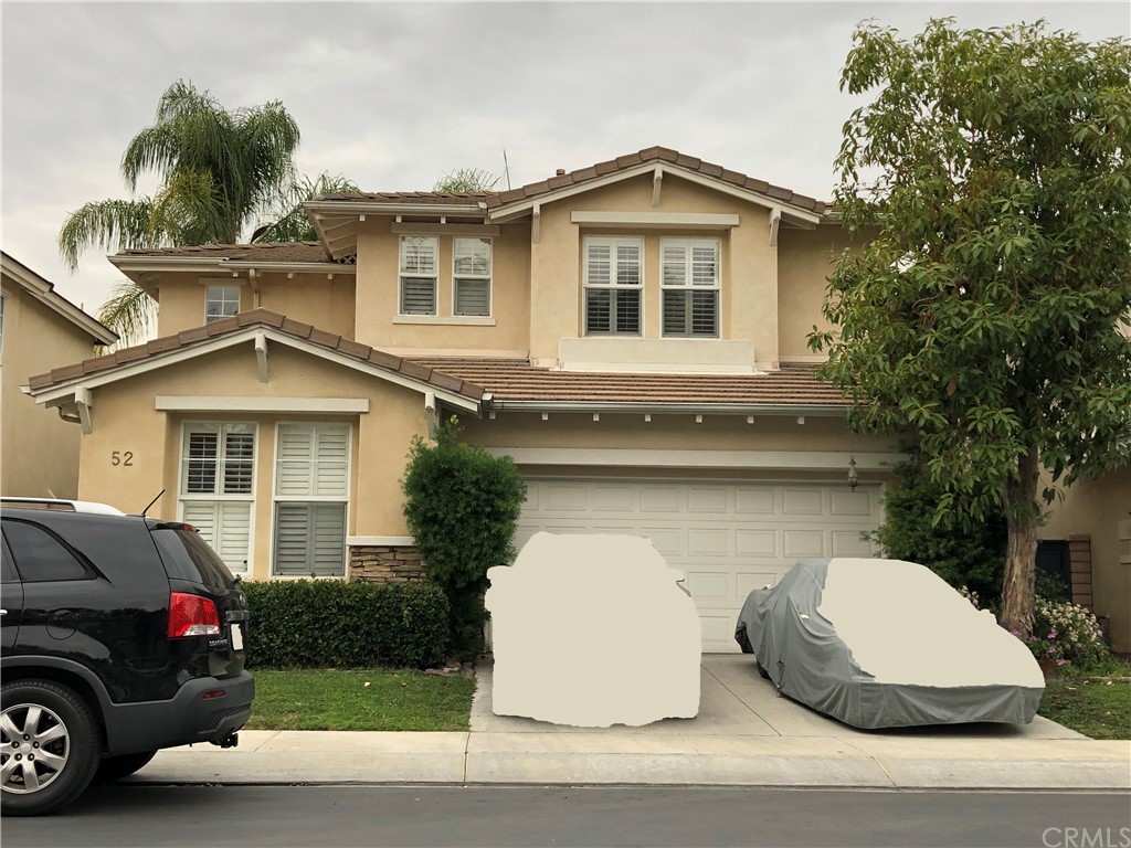 a front view of a house with a garden and plants
