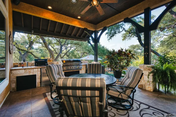 an aerial view of residential house with outdoor space and trees all around