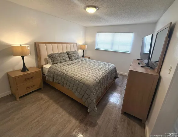 a bedroom with bed cabinet and window
