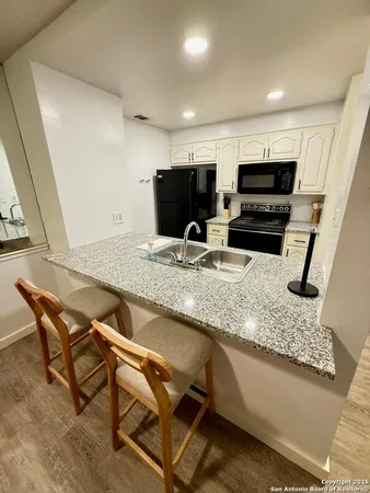 a kitchen with stainless steel appliances granite countertop a stove a sink and a microwave