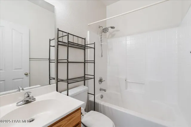 an empty room with windows and a ceiling fan