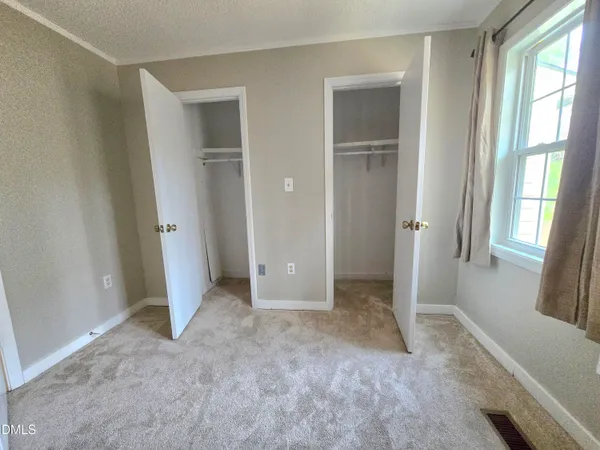 an empty room with windows and ceiling fan view