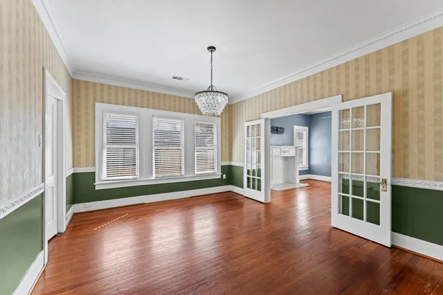 a view of empty room with wooden floor and floor to ceiling window