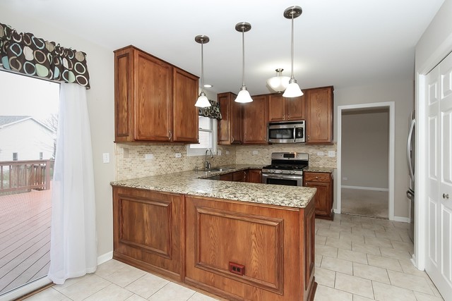 2784 Randall Ridge Drive Elgin, IL 60124 - Photo 5 of 20 a kitchen with stainless steel appliances granite countertop a stove a sink and a refrigerator