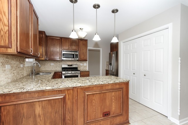 2784 Randall Ridge Drive Elgin, IL 60124 - Photo 6 of 20 a kitchen with stainless steel appliances granite countertop a sink a stove a refrigerator and cabinets