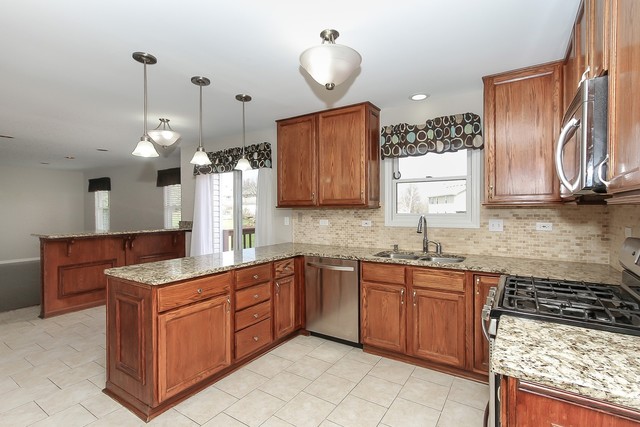 2784 Randall Ridge Drive Elgin, IL 60124 - Photo 7 of 20 a kitchen with kitchen island granite countertop a sink counter top space appliances and cabinets