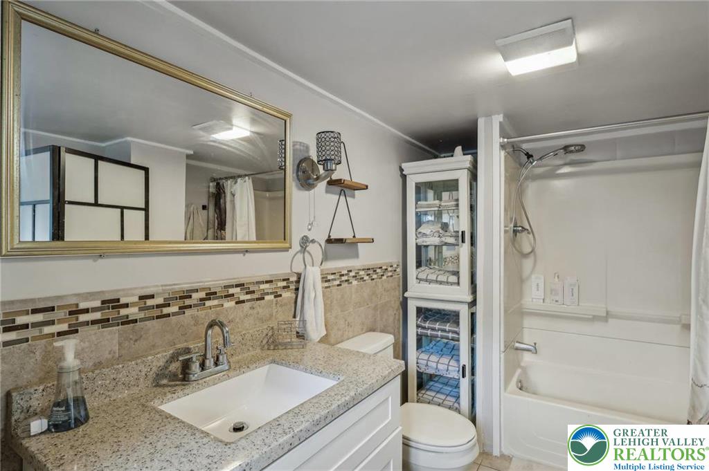 3203 Washington Street Bethlehem, PA 18020 - Photo 4 of 14 a bathroom with a granite countertop sink toilet a shower and a mirror