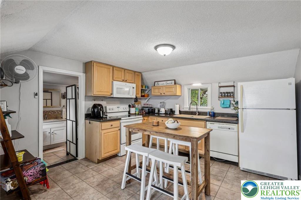 3203 Washington Street Bethlehem, PA 18020 - Photo 7 of 14 a kitchen with stainless steel appliances granite countertop a refrigerator a stove a sink dishwasher and white cabinets with wooden floor