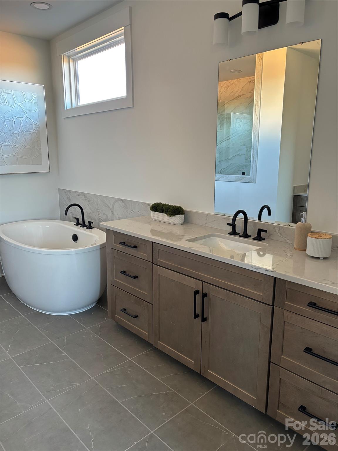 1027 Cox Road, Unit 12 Weddington, NC 28104 - Photo 19 of 32 a spacious bathroom with a double vanity sink a mirror and a bathtub