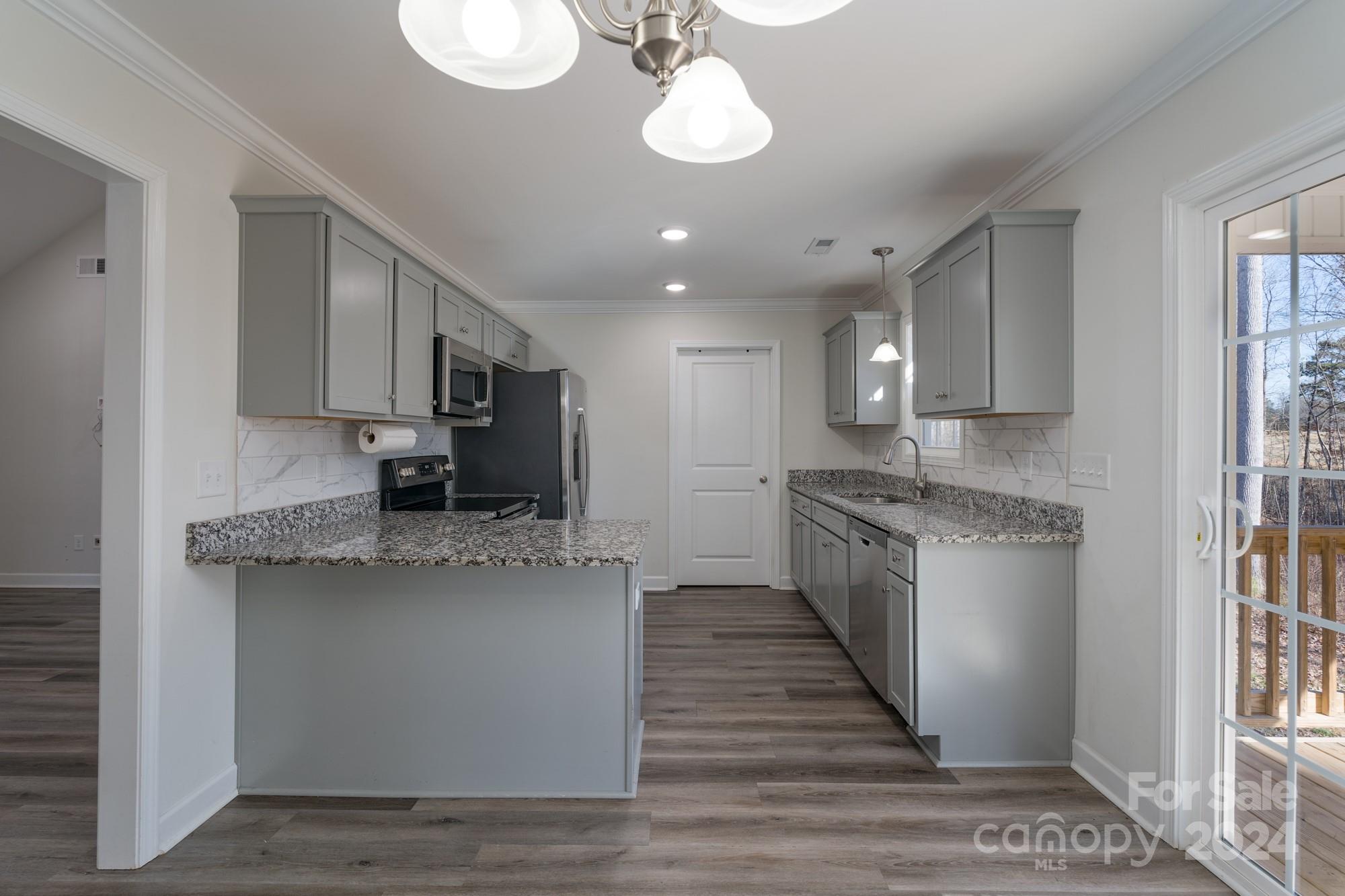 1121 Thompson Davis Road York, SC 29745 - Photo 8 of 28 a large kitchen with stainless steel appliances granite countertop a lot of counter space and wooden floor