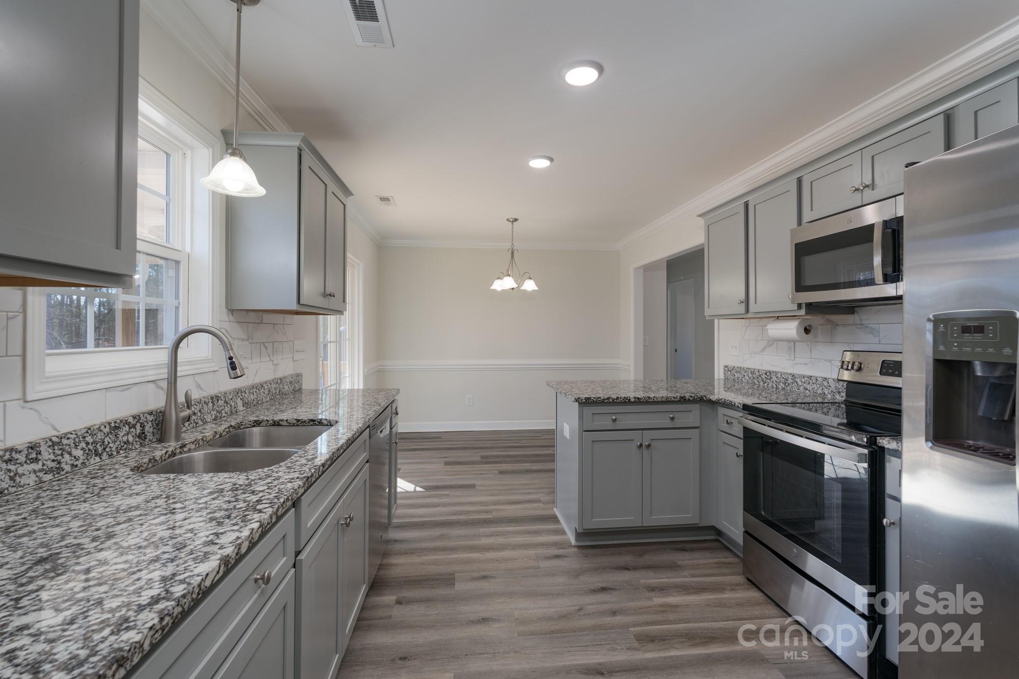 1121 Thompson Davis Road York, SC 29745 - Photo 10 of 28 a kitchen with stainless steel appliances granite countertop a sink stove and microwave