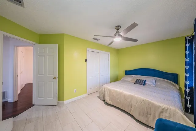 a bedroom with a bed and a ceiling fan