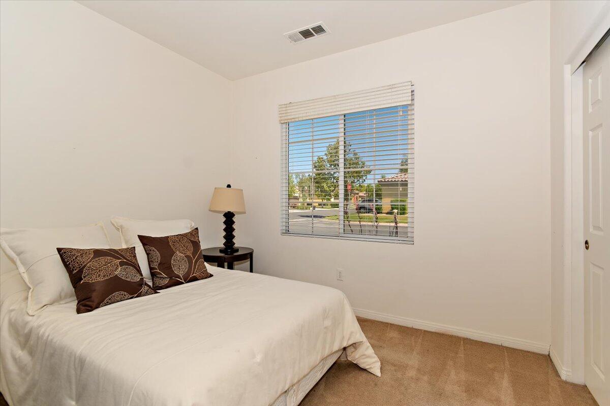 49528 Pacino Street Indio, CA 92201 - Photo 14 of 22 a bedroom with a bed and window