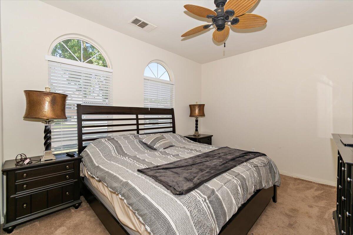 49528 Pacino Street Indio, CA 92201 - Photo 15 of 22 a bedroom with a bed and a chandelier