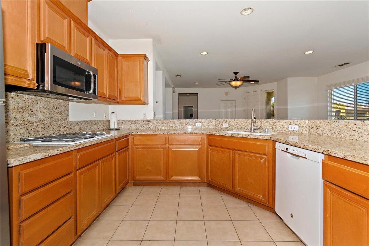 49528 Pacino Street Indio, CA 92201 - Photo 8 of 22 a kitchen with stainless steel appliances granite countertop a sink and a stove top oven with granite countertops