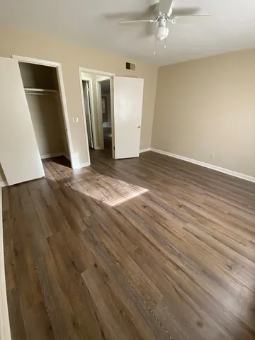 an empty room with wooden floor and entryway