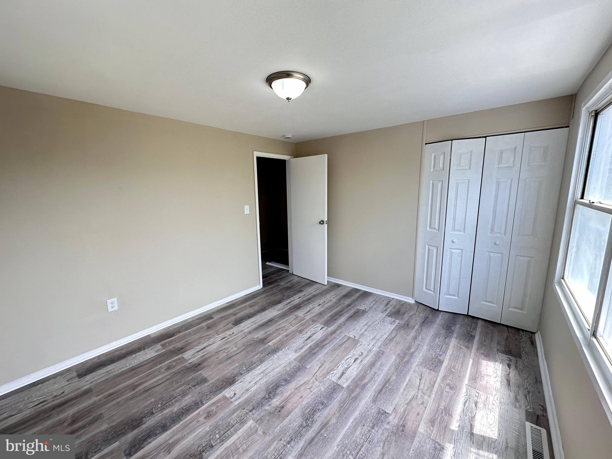 8039 Gough Street Baltimore, MD 21224 - Photo 12 of 17 a view of an empty room with wooden floor and a window